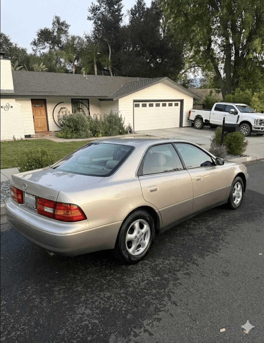 Champagne metallic Lexus ES 300 sedan parked on a residential street with like-new paint and trim