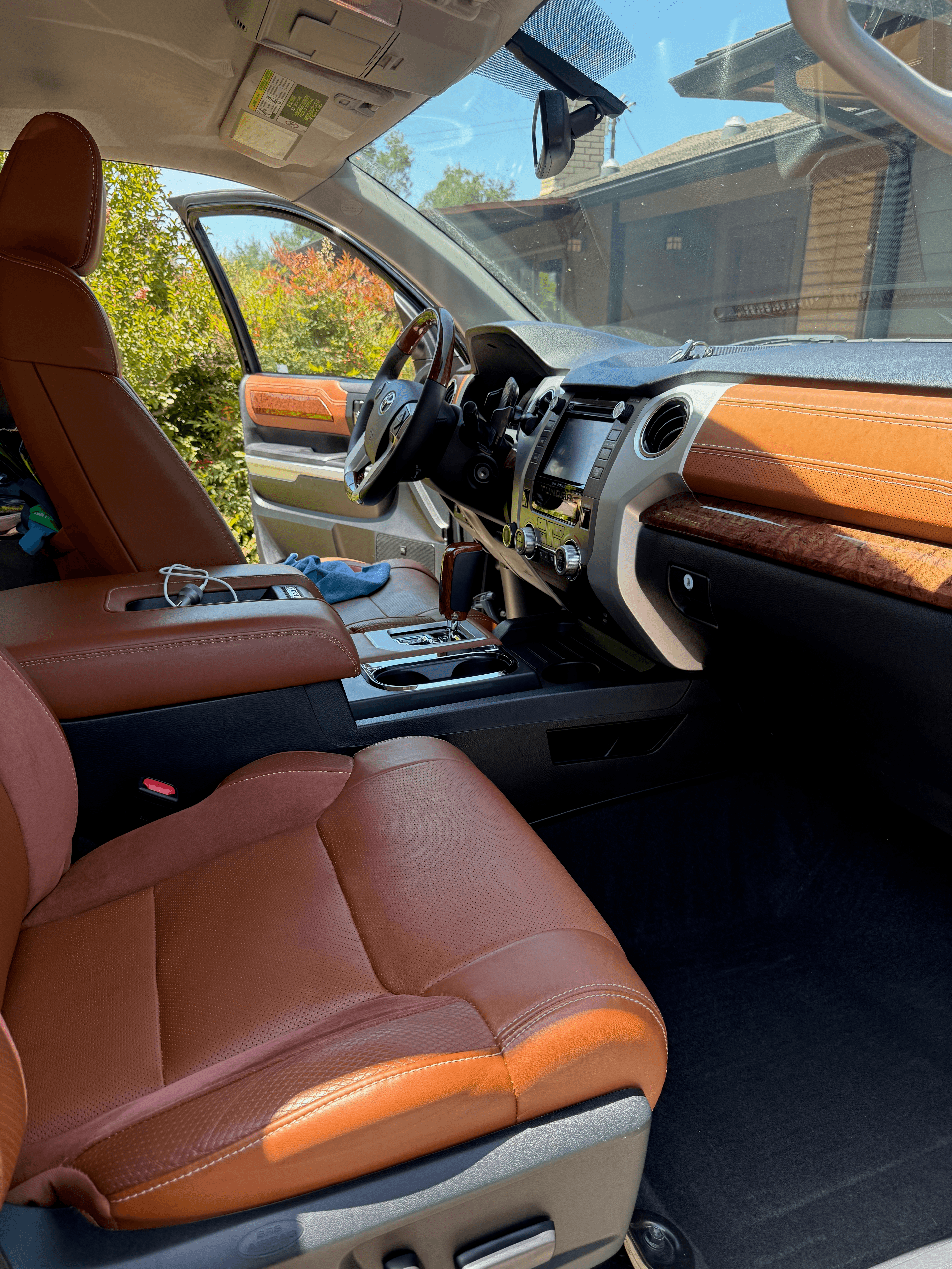 Brown leather and wood-trimmed Toyota truck interior with open driver door and refreshed cabin surfaces